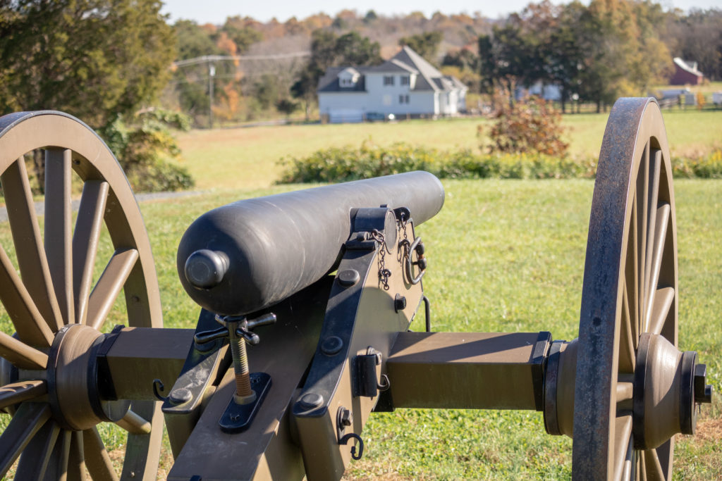 Picture of a civil war cannon taking aim in a field.