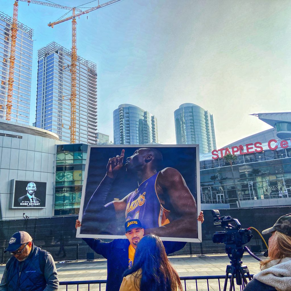 Picture outside the Staples Center of a fan holding a Kobe Bryant poster.